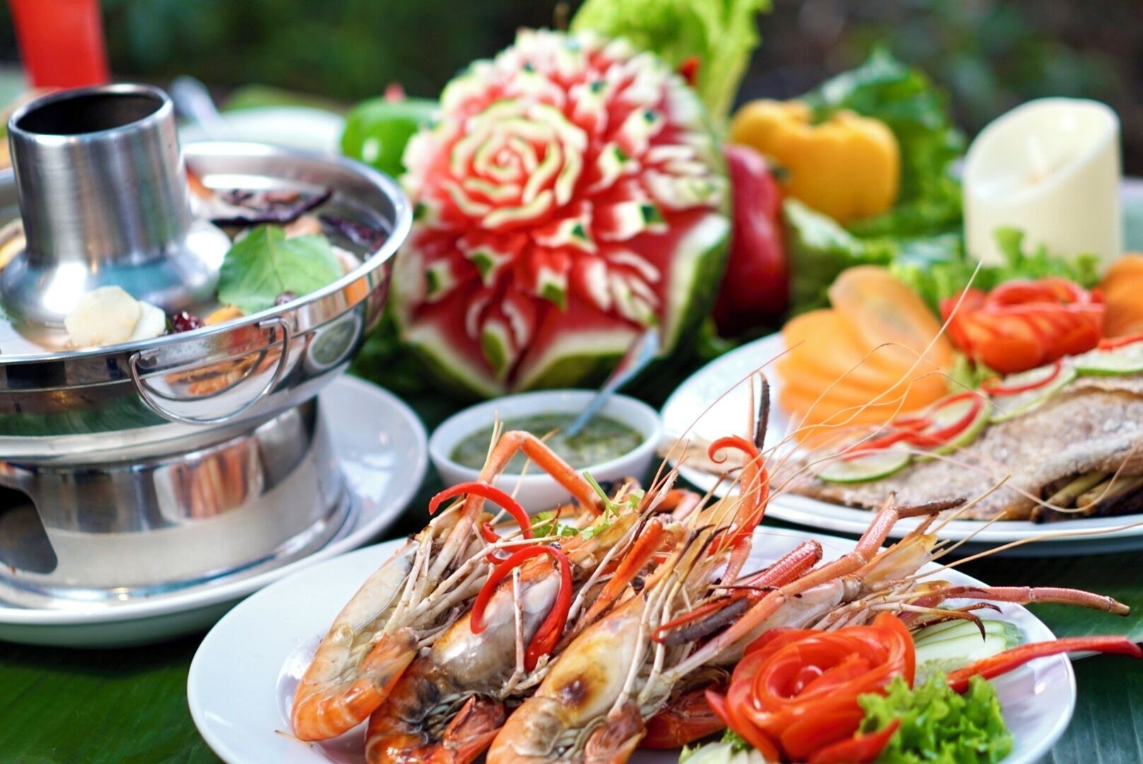Uma mesa com mariscos, vegetais e um pote quente.