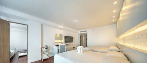 A modern hotel room with a large bed, a desk, a chair, a wardrobe, and a bathroom.