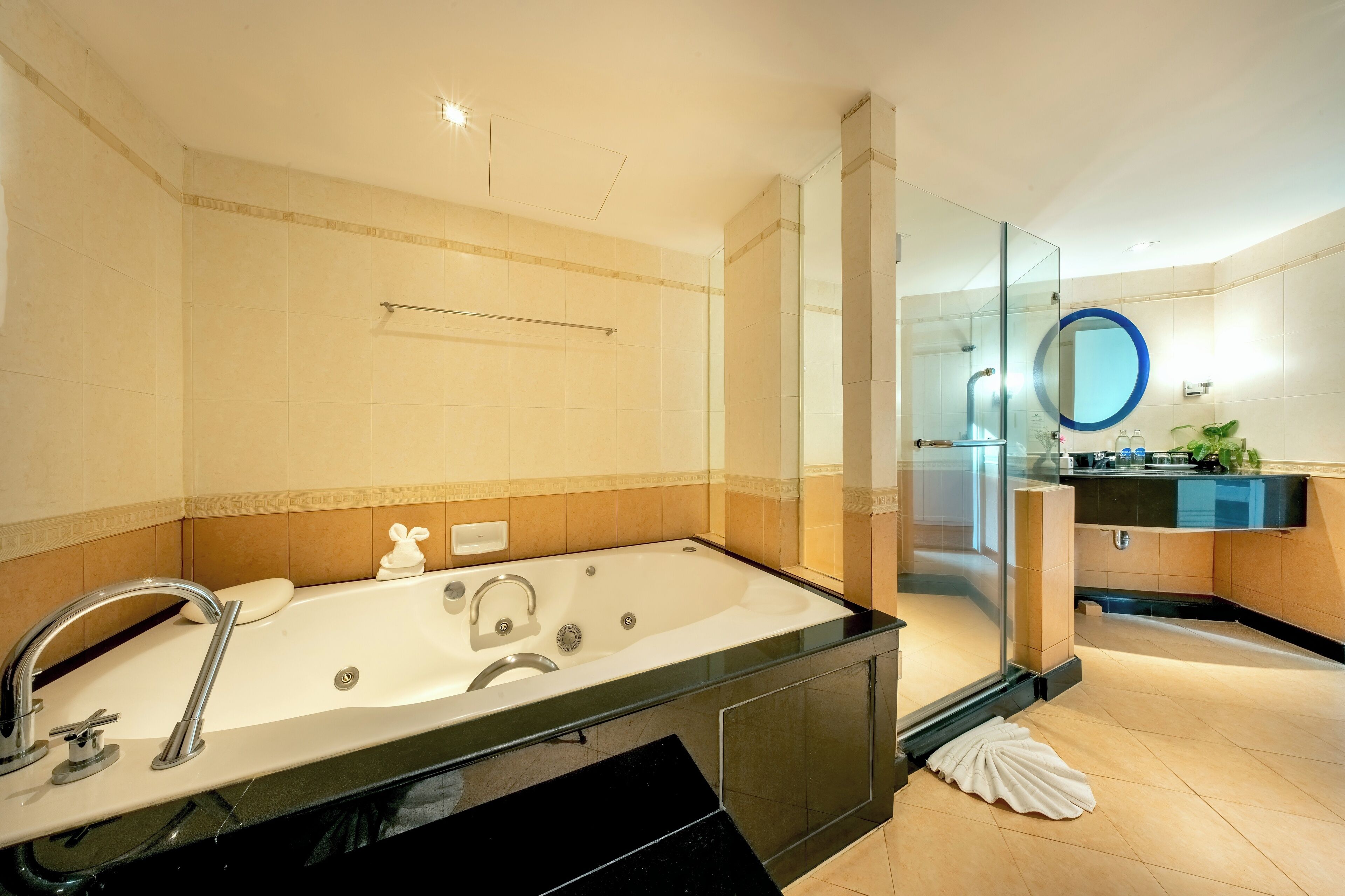 A modern bathroom with a large bathtub, a glass-enclosed shower, and a vanity with a mirror.