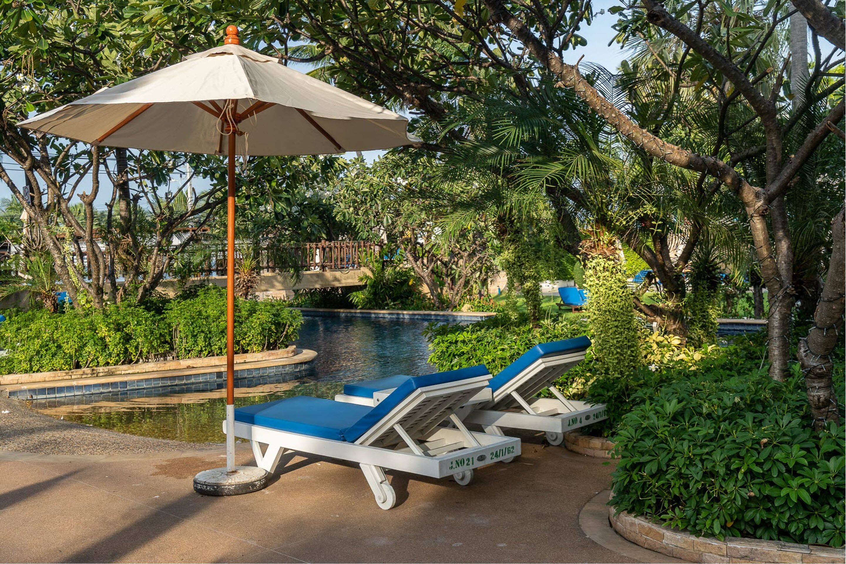 A poolside area with lounge chairs and an umbrella.
