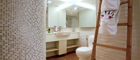 Une salle de bain moderne avec un plancher en bois, des toilettes blanches, un lavabo et un miroir.