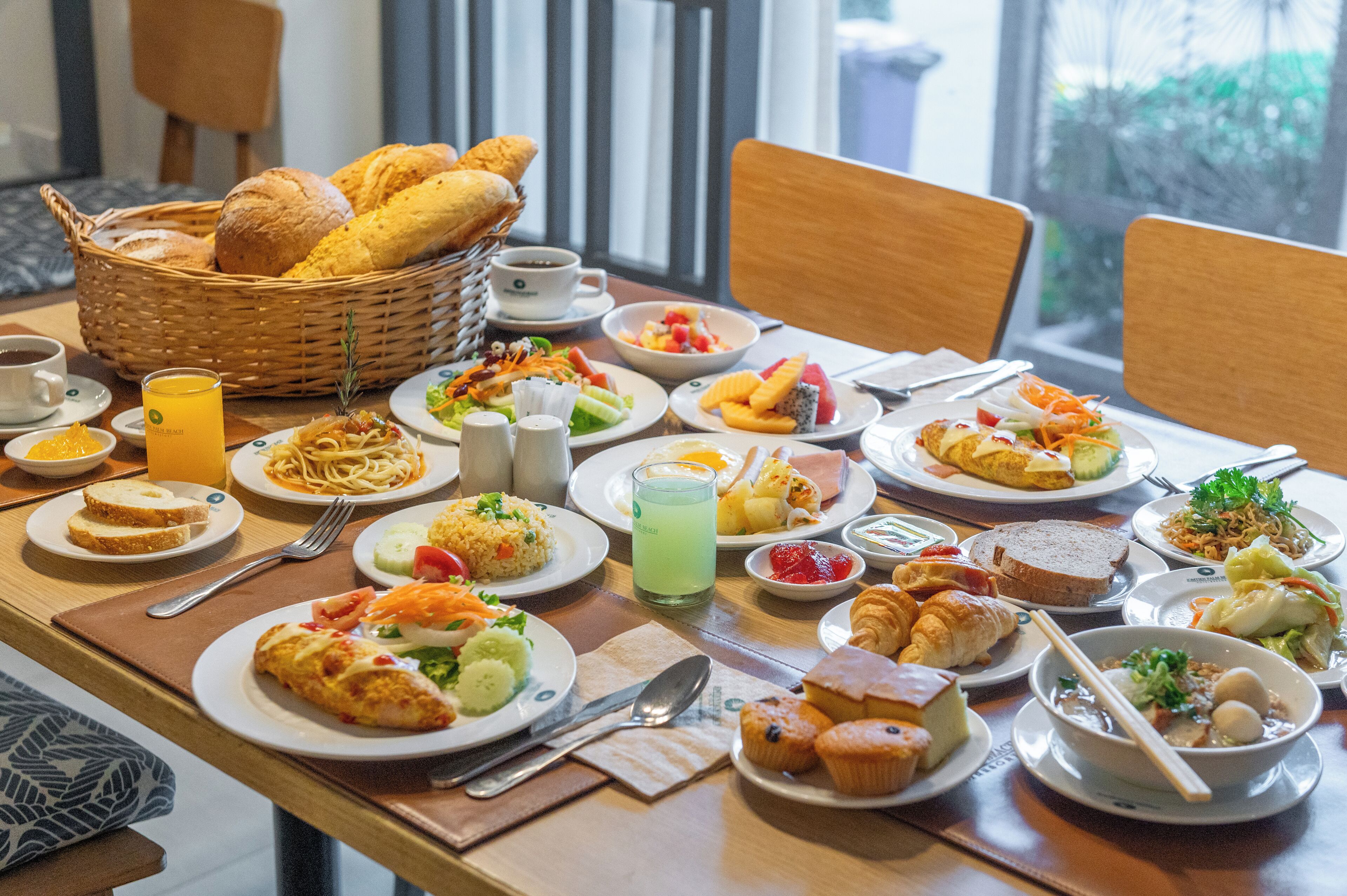 A breakfast buffet with various dishes, including bread, fruits, and pastries.