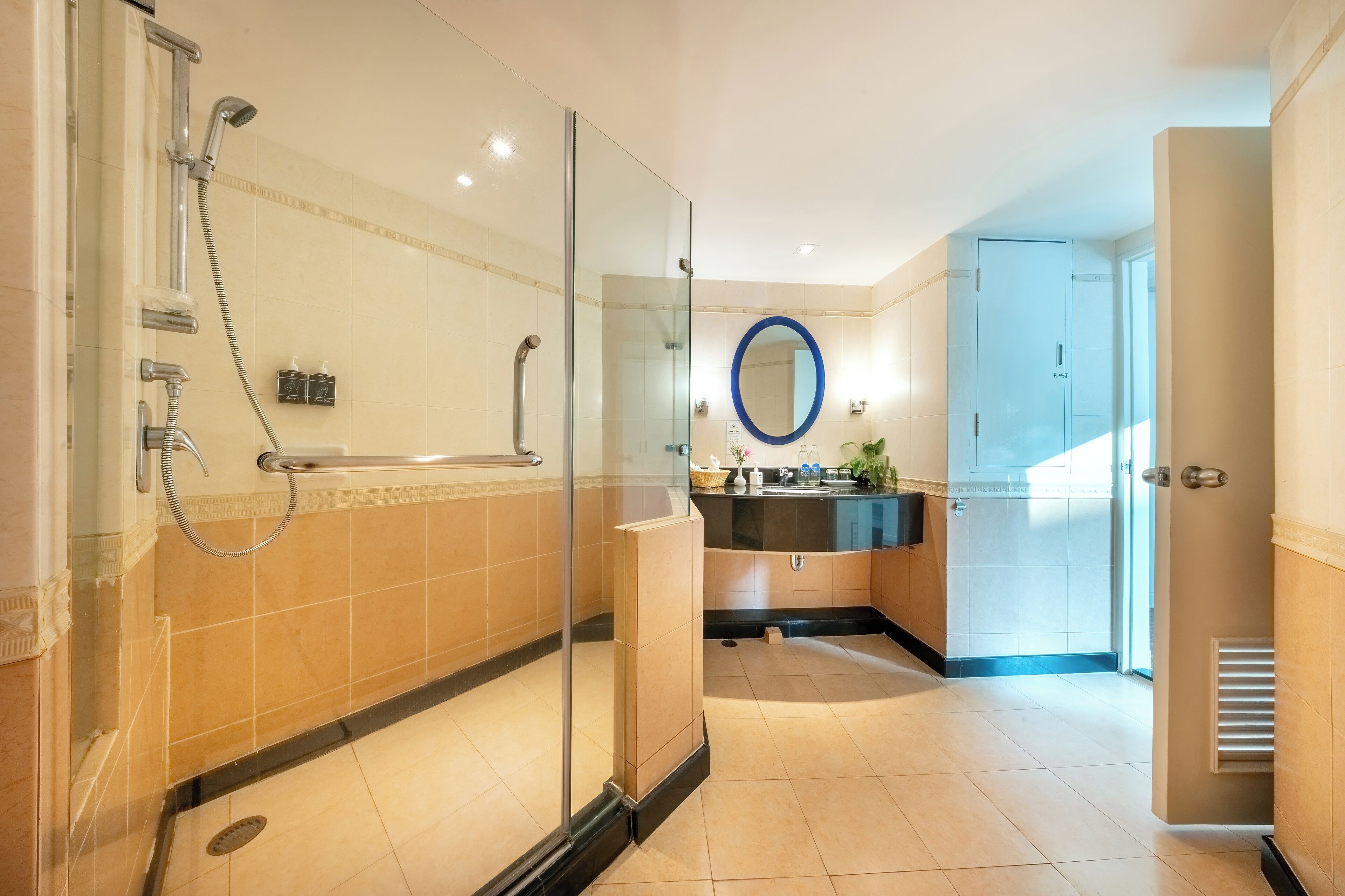 A modern bathroom with a glass-enclosed shower, a vanity with a sink, and a large mirror.