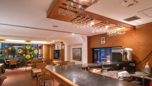 A restaurant with a bar area, wooden ceiling, and hanging light fixtures. - The Residence Rajtaevee Hotel (Bangkok)