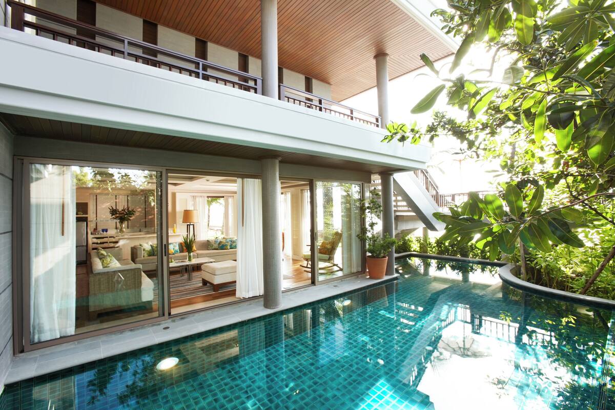 Un edificio moderno con piscina, ventanas amplias y plantas de interior.