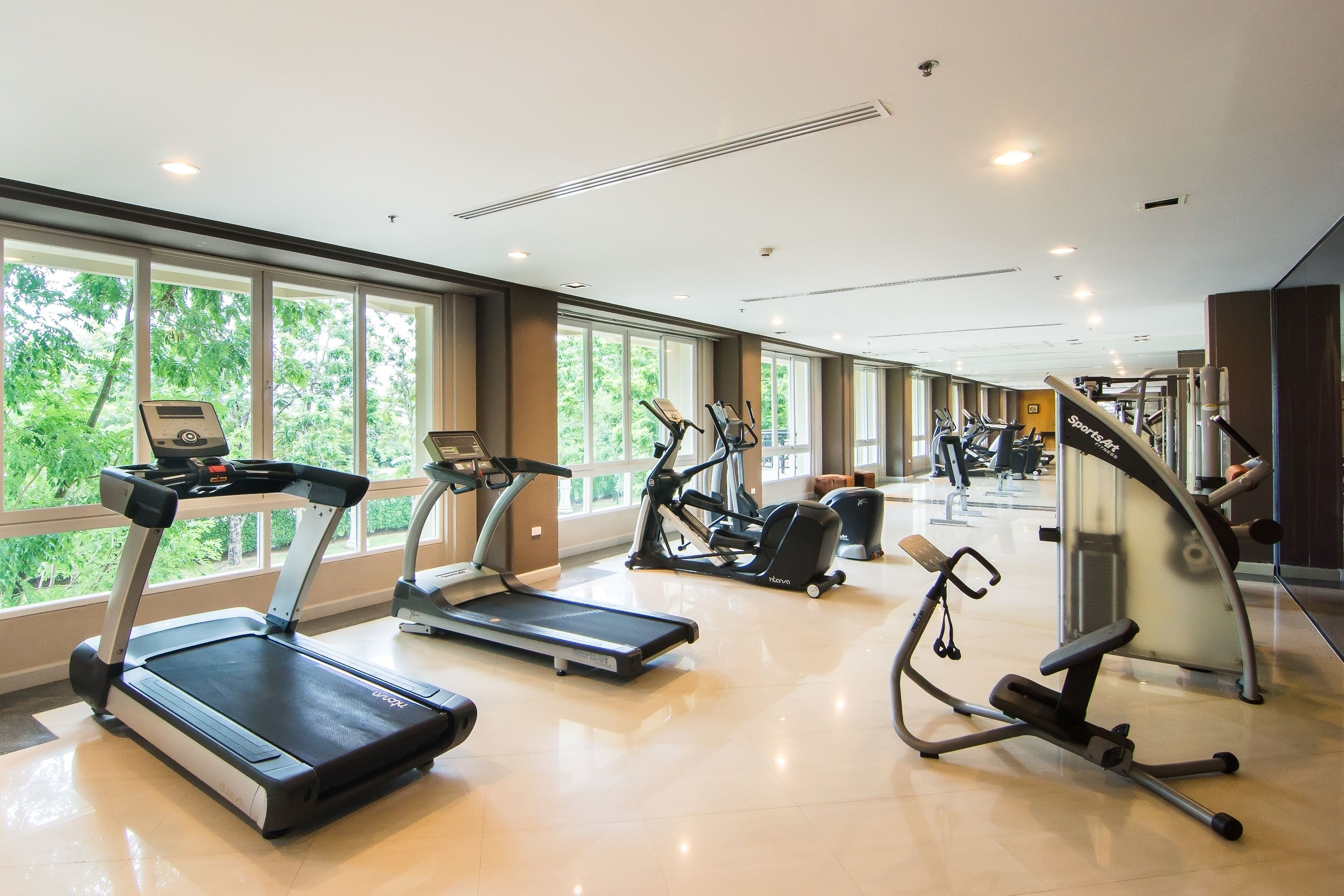 Ein modernes Fitnessstudio mit Laufbändern, Crosstrainern und Gewichtstrainern.