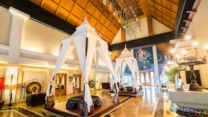 Eine luxuriöse Lobby mit einem großen Himmelsbett, bequemen Sitzgelegenheiten und einer prächtigen Kronleuchter.