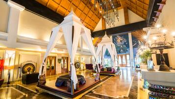 Experience the grandeur of our lobby, featuring a majestic bed with a canopy, a reception desk, and plush seating areas.