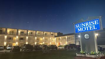A motel with a prominent sign reading "SUNRISE MOTEL".