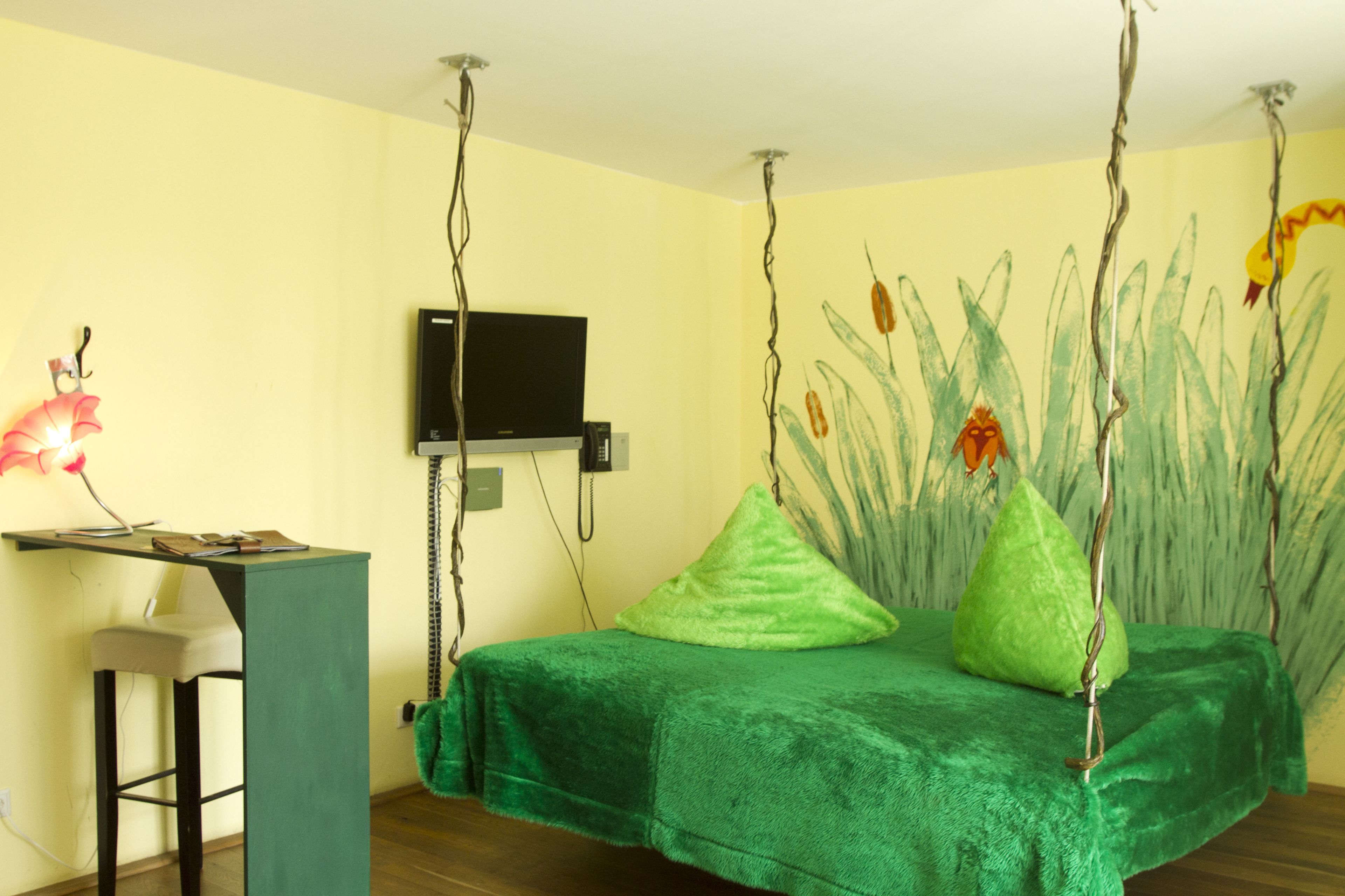 Een kamer met een bed, bureau en televisie.