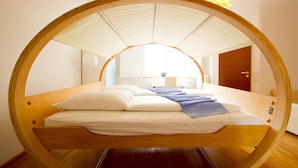 Habitación circular con una cama centrada bajo un dosel blanco.