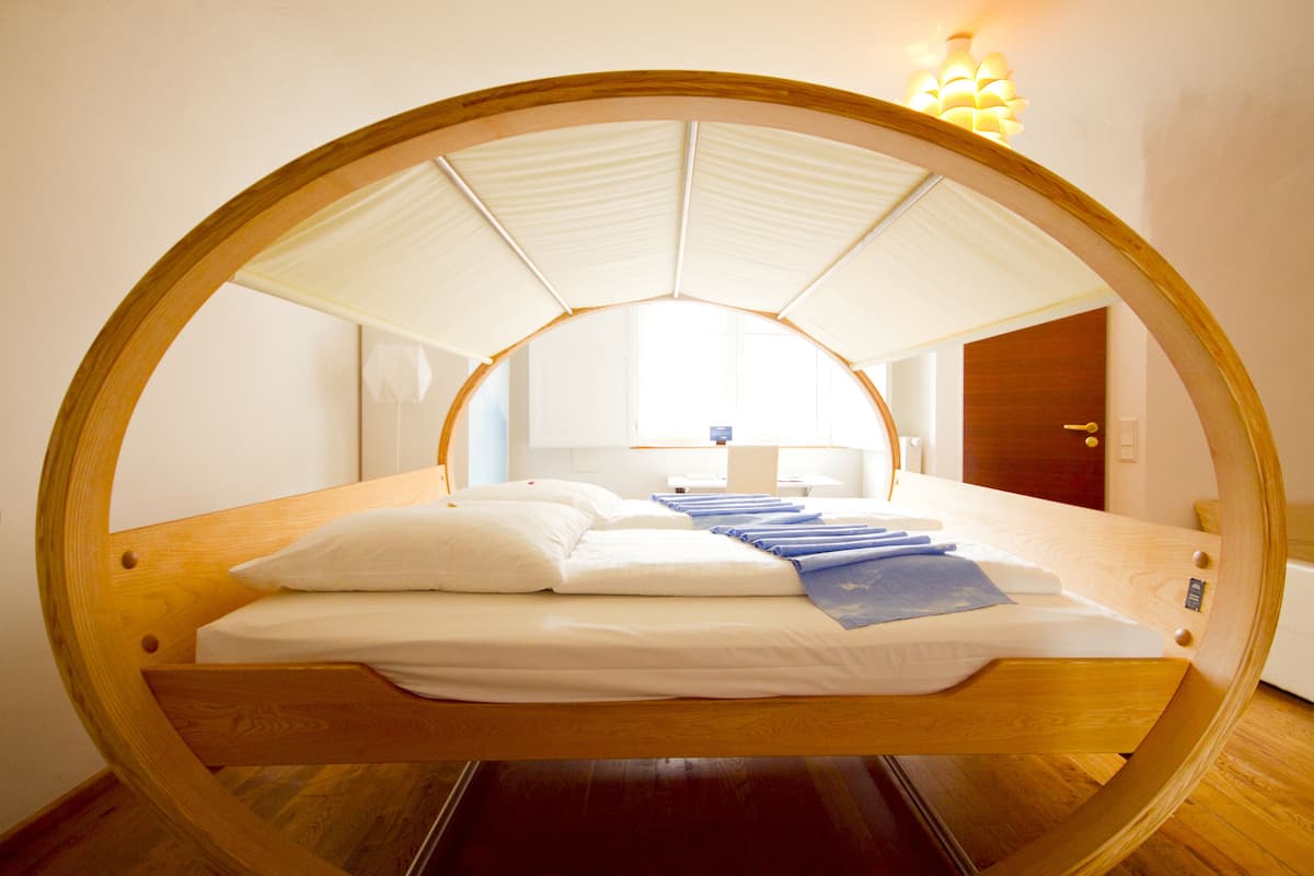 Une pièce circulaire avec un lit placé au centre, sous un dais blanc.