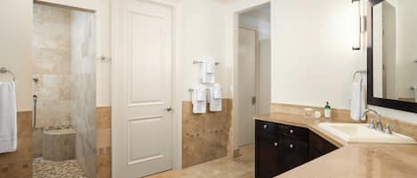 A modern bathroom with a shower, sink, and large mirror.