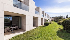 Un edificio moderno con techo plano, ventanas amplias y un jardín bien cuidado.