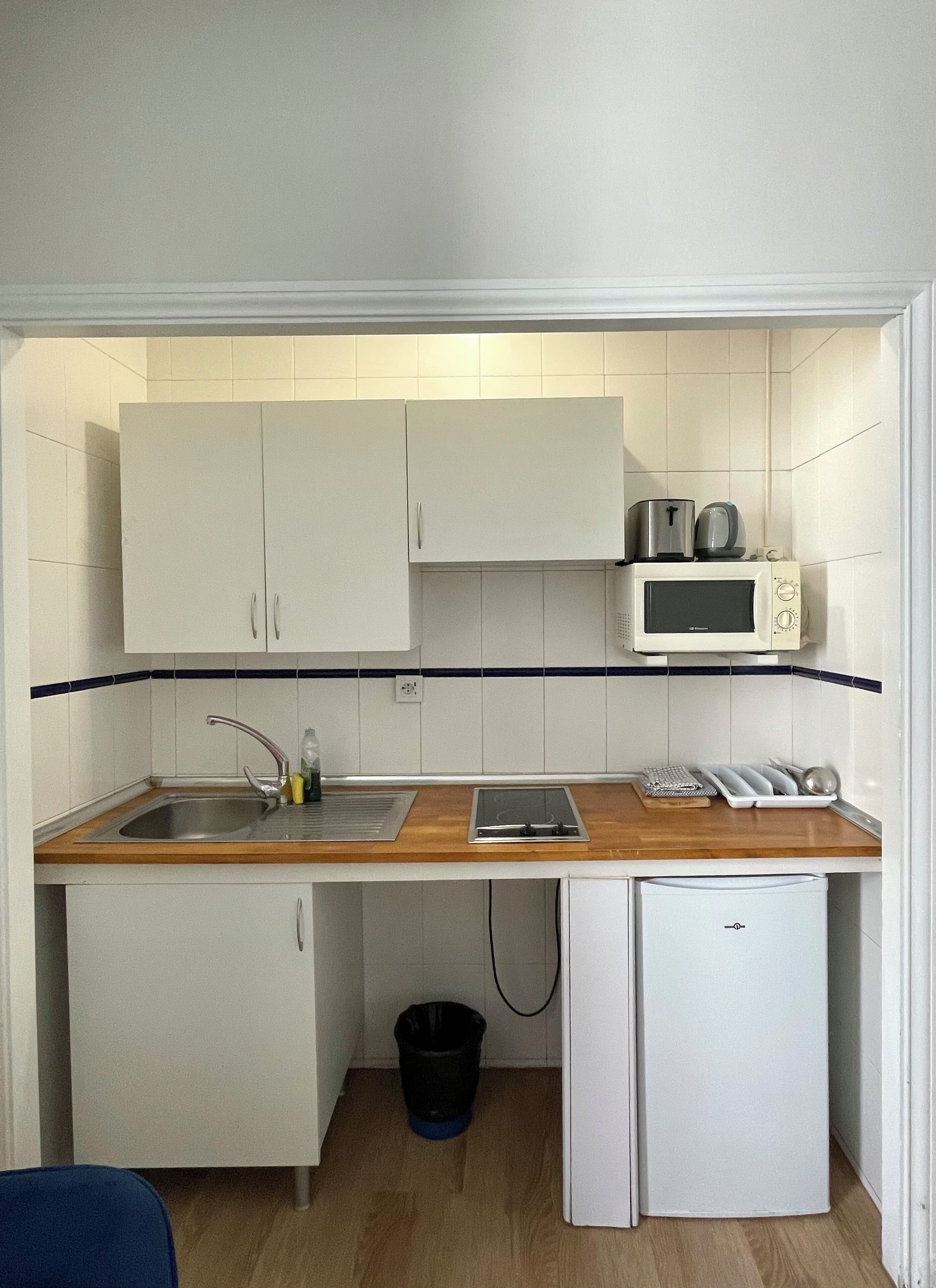 A compact kitchenette with a sink, microwave, and small refrigerator.