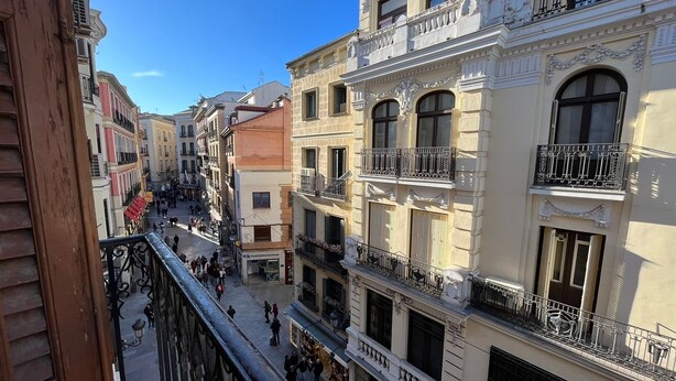 A narrow street lined with multi-story buildings featuring balconies and ornate architectural details. - Apartamentos Mayor Centro (Madrid)