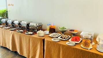 A buffet setup with various food items and condiments.