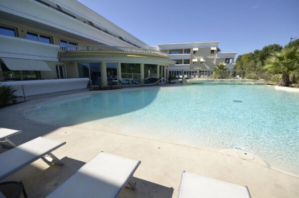 Piscine extérieure, parasols de plage, chaises longues
