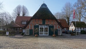 A traditional building with a steeply pitched roof, a triangular gable, and a large central window.
