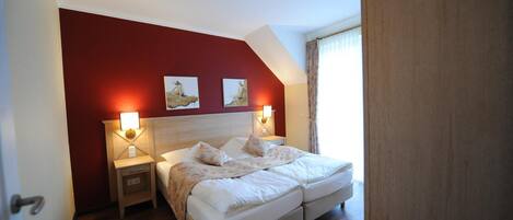 A bedroom with a large bed, two bedside tables, and a ceiling light.