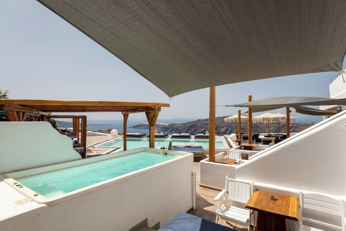 A rooftop pool area with multiple pools, outdoor seating, and a view of the ocean.