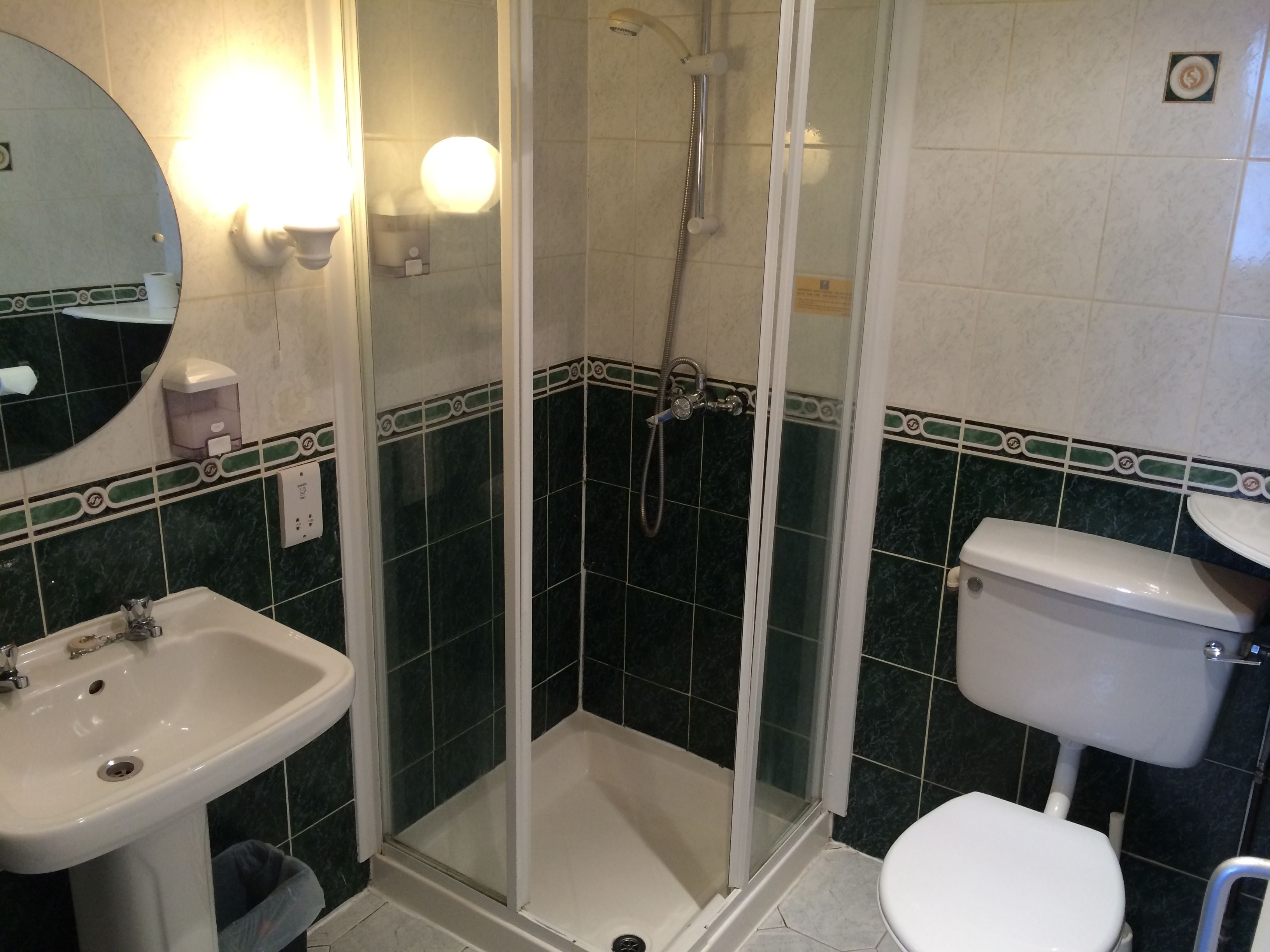 Ein Badezimmer mit Dusche, Waschbecken und Toilette.