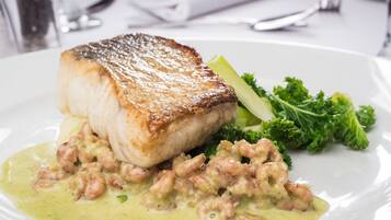 Un plato con pescado, camarones y verduras.