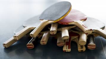 Een verzameling houten tafeltennispaddles en een paddle op een donkere ondergrond.