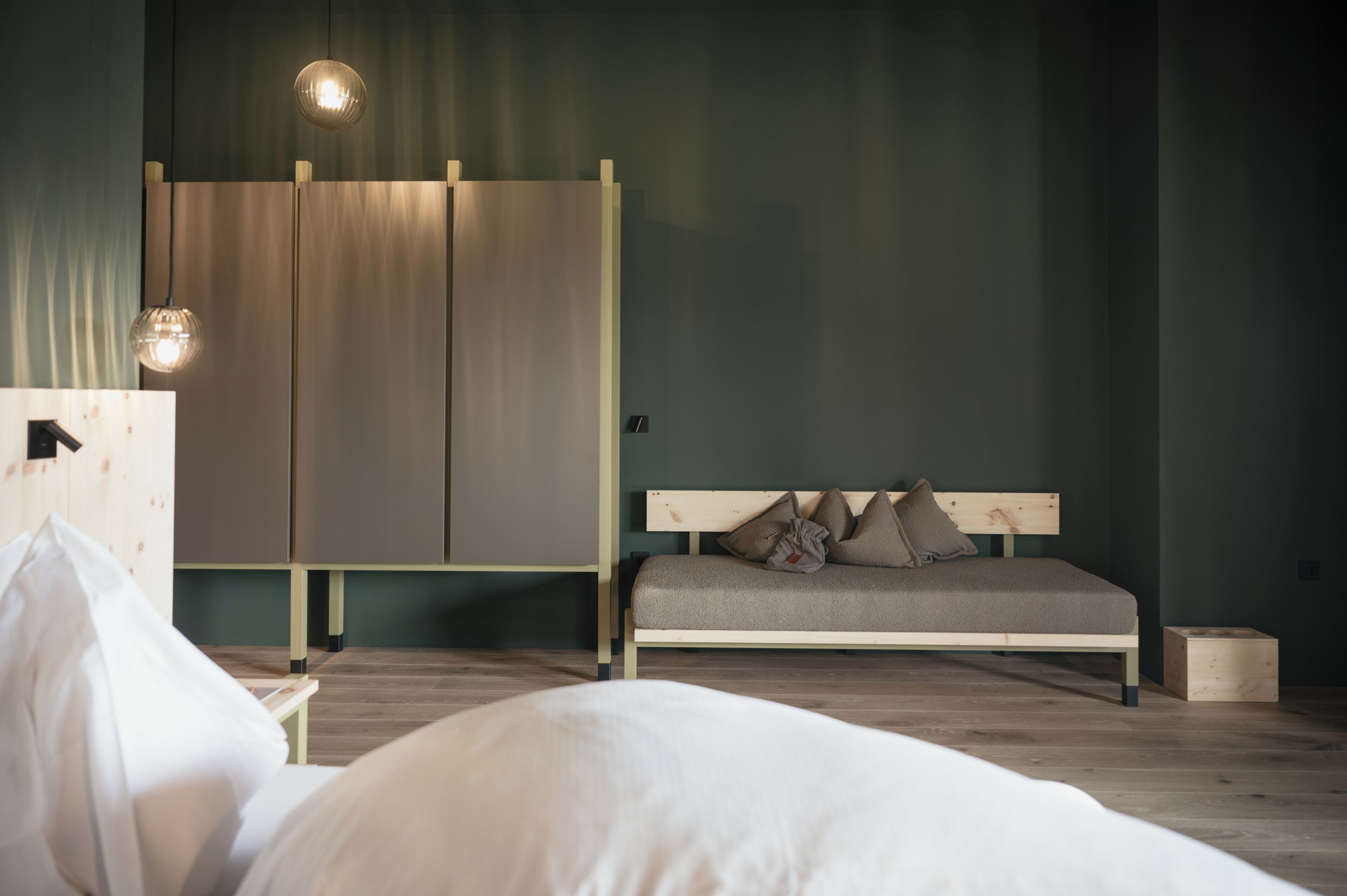 Una camera da letto con un letto, una testiera in legno, un armadio e un comodino.