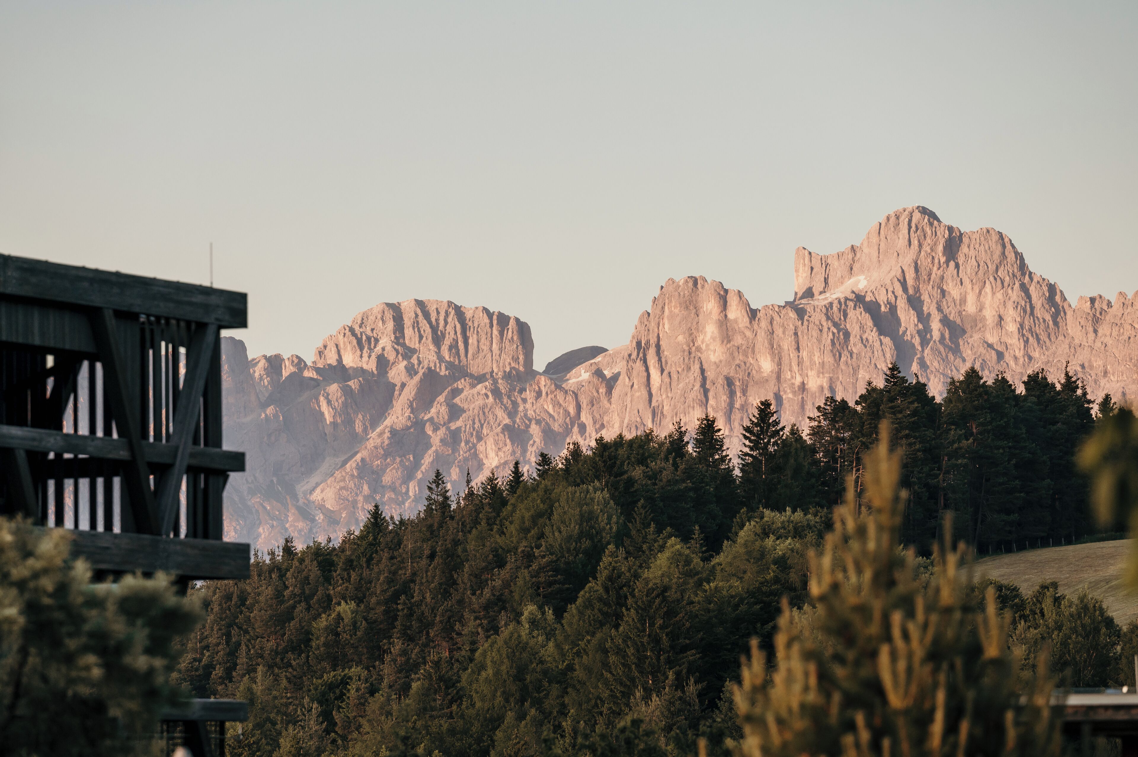 A mountainous landscape with a wooden structure in the foreground.