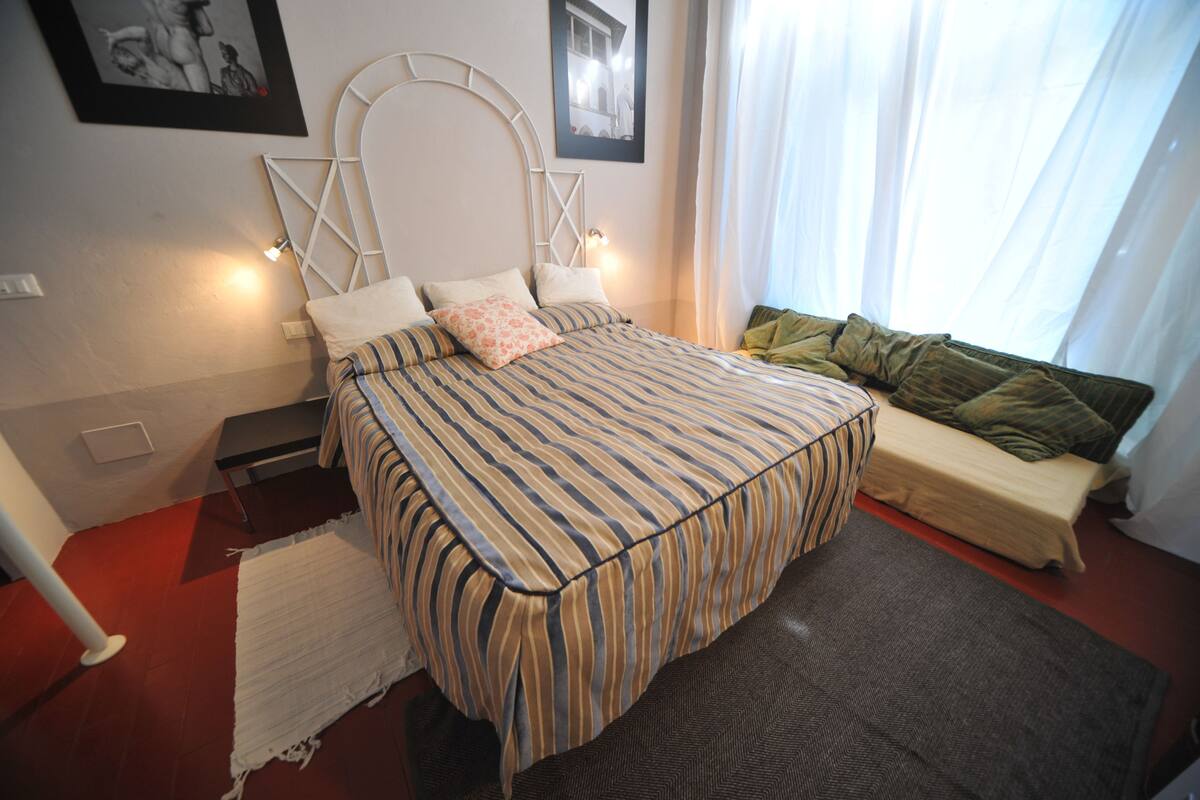 A neatly arranged bedroom with a bed, bedside tables, and a bench.