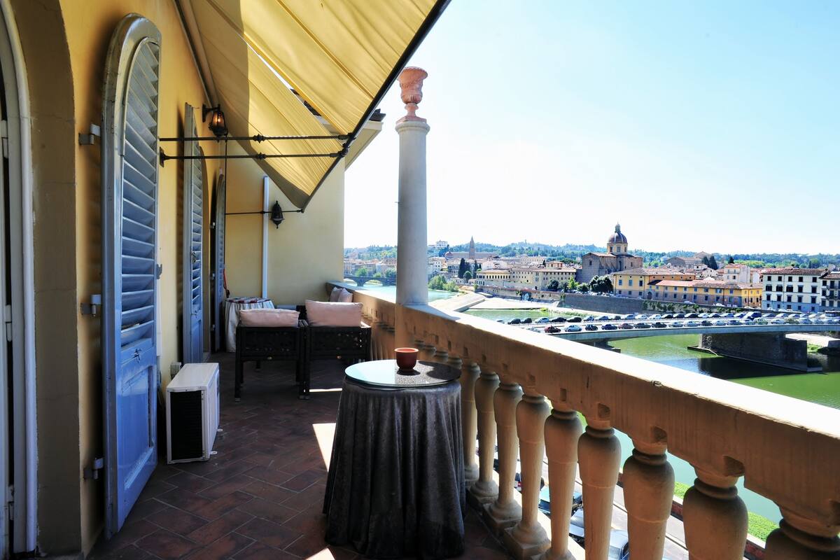 A balcony with a view of a cityscape, including a prominent dome and a bridge.