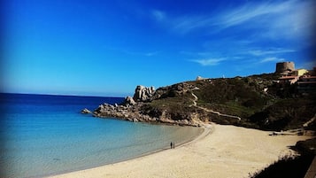 Plage à proximité, sable blanc, parasols, serviettes de plage