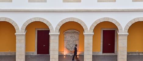 A building with arched doorways and a central stone sculpture.