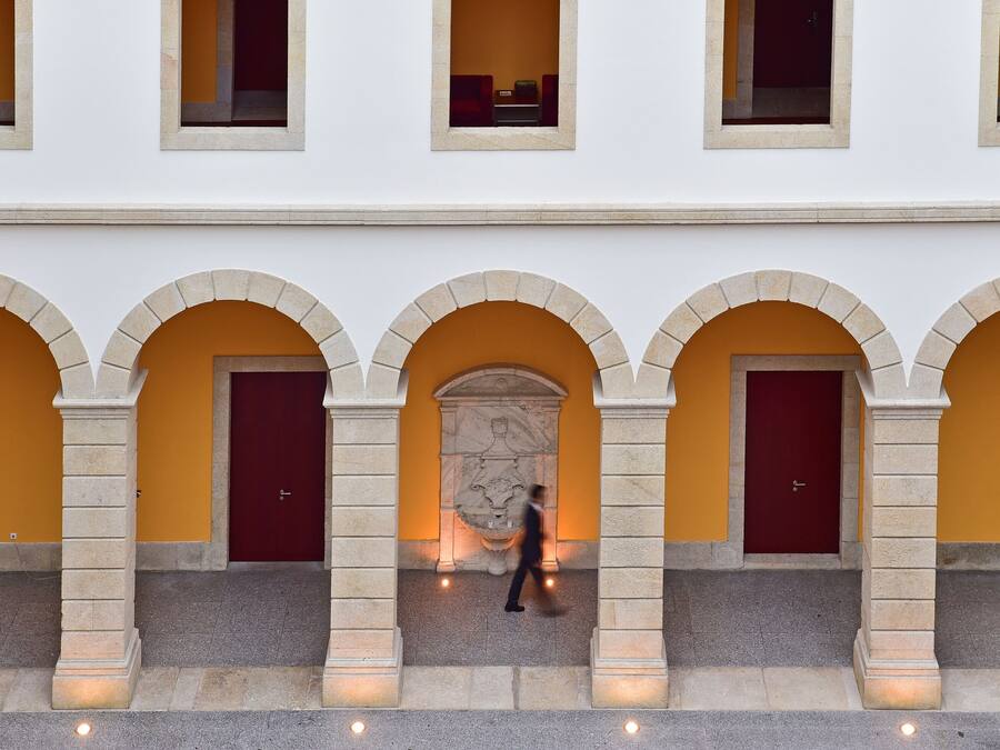 A building with arched doorways and a central stone sculpture.