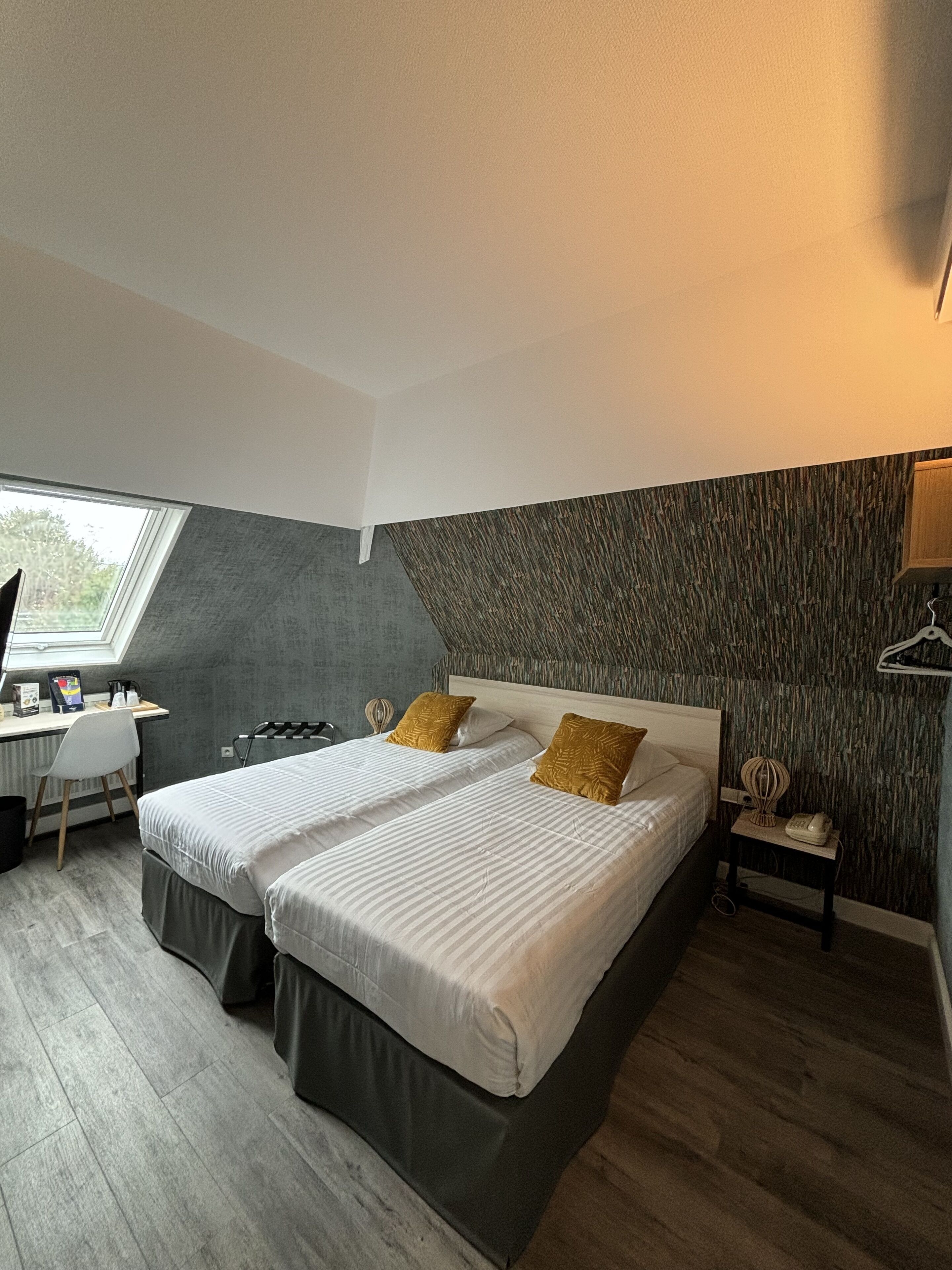 Une chambre moderne avec deux lits, un bureau et une chaise.