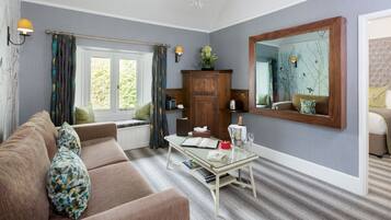 A living room with a sofa, a glass coffee table, a wooden cabinet, and a large mirror.