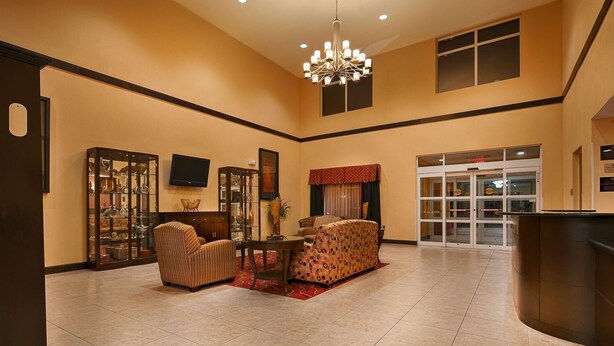 A spacious lobby with a chandelier, a television, and a reception desk. - Best Western Plus Jacksonville West (Jacksonville)