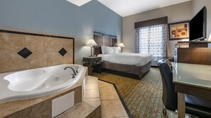 A hotel room with a large bathtub, a bed with two pillows, a desk with a flat-screen TV, and a window with patterned curtains. - Best Western Plus Bradenton Gateway Hotel (Bradenton)