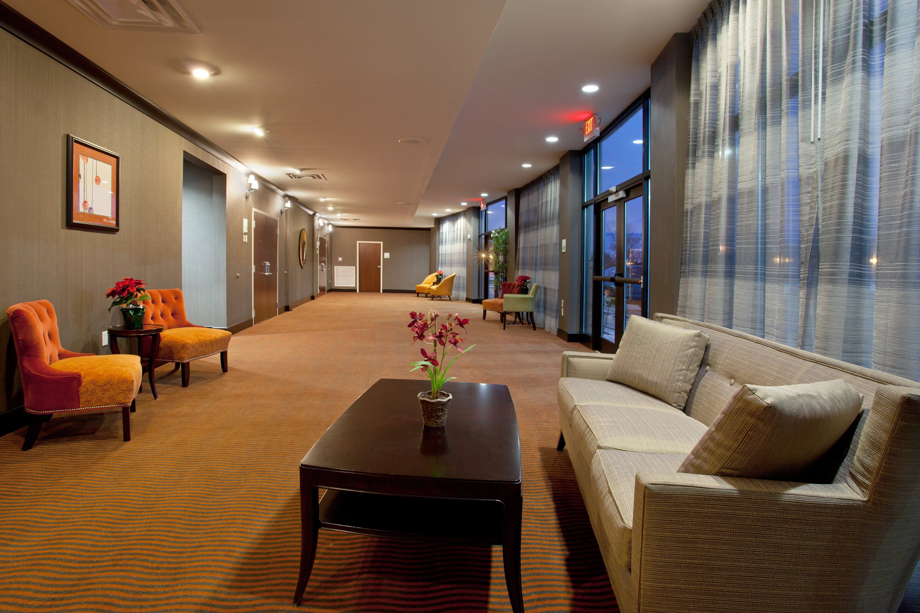 Un hall de hotel con mostrador de recepción, zona de estar y amplias ventanas.