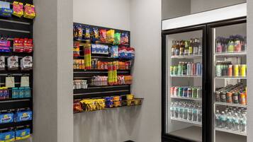 Un espace proposant des distributeurs automatiques de collations et de boissons, avec un assortiment varié de produits.