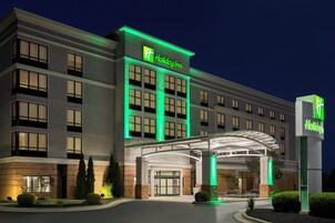 A Holiday Inn hotel with a modern facade, large windows, and a well-lit entrance.