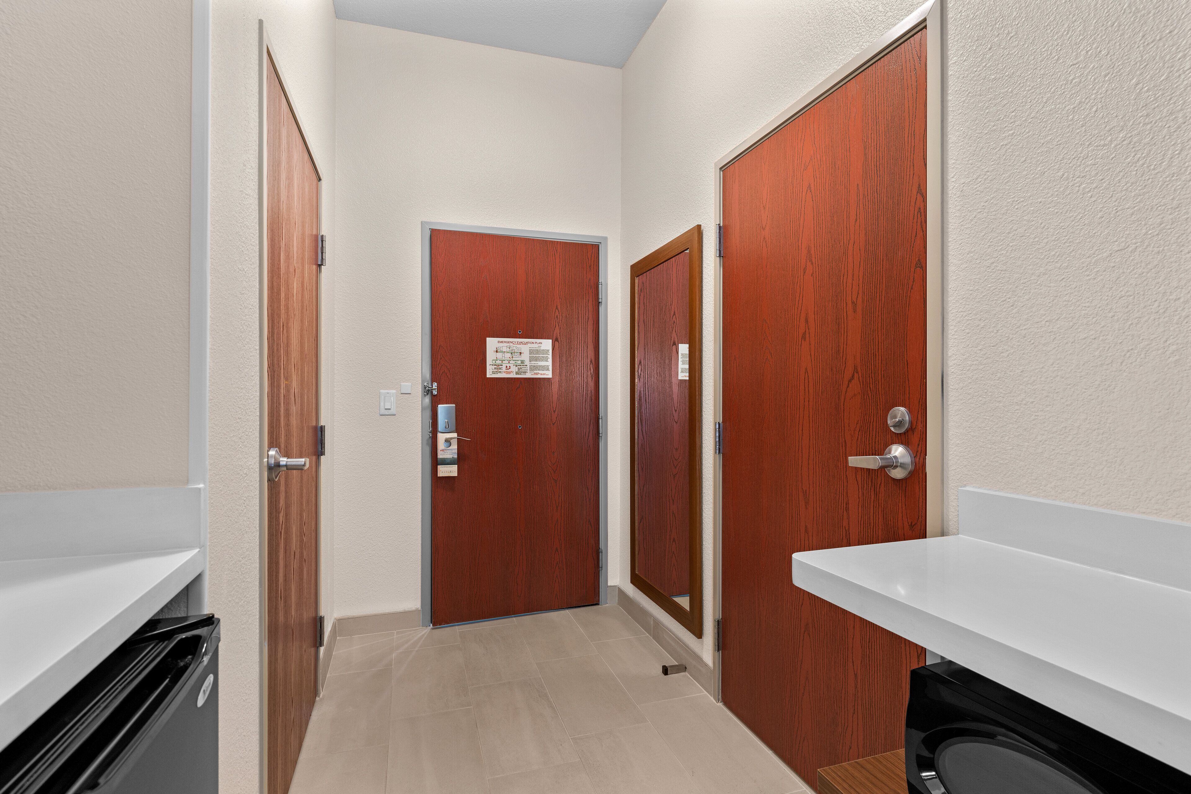 A narrow hallway with wooden doors and a white sink.