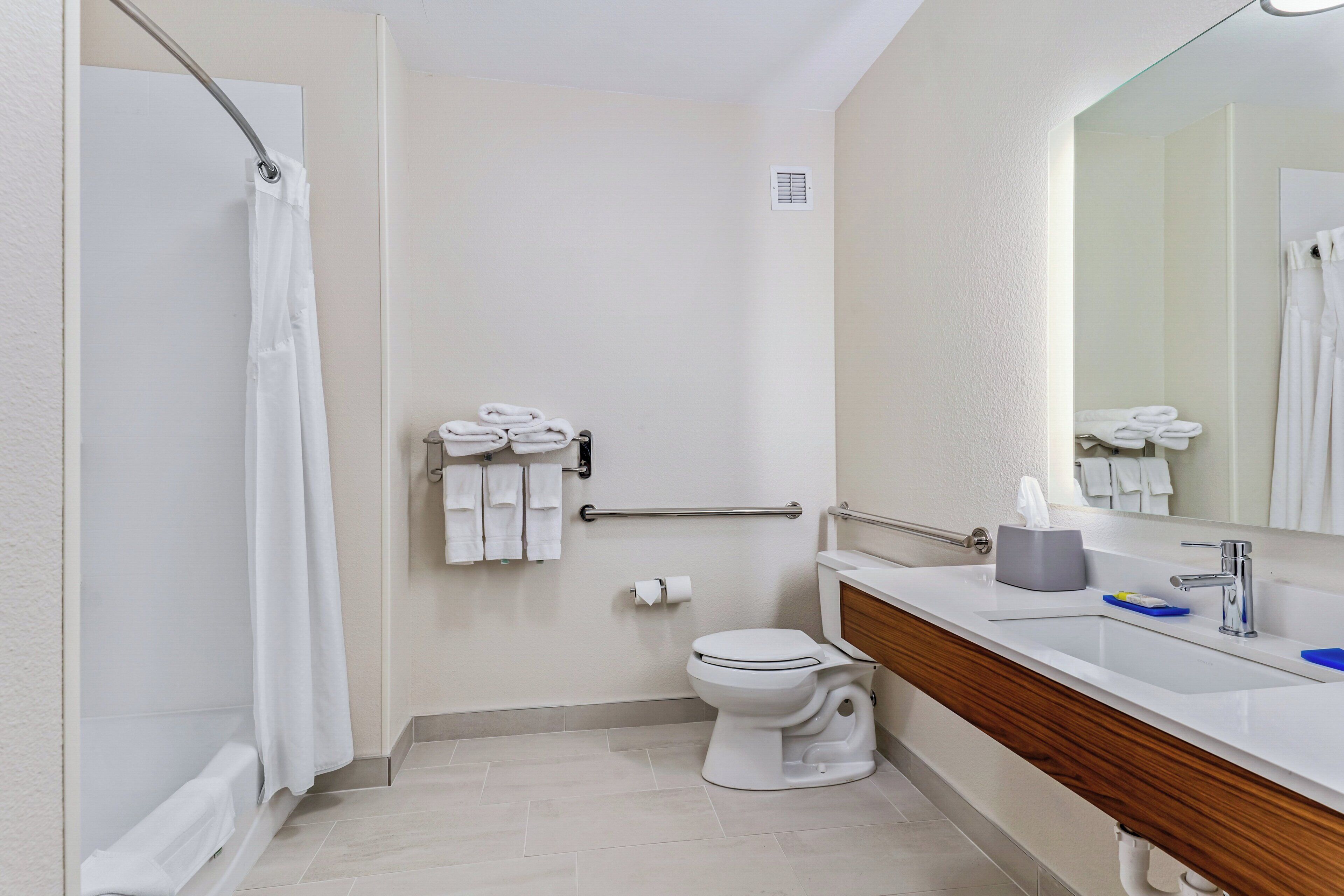 Un baño con ducha, inodoro y lavabo.