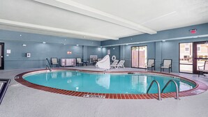 An indoor swimming pool with a diving board, lounge chairs, and a covered seating area. - Holiday Inn Express Suites Van Buren-Ft Smith Area by IHG (Van Buren)