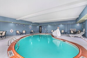 An indoor swimming pool with a tiled edge, lounge chairs, and a lifebuoy on the wall. - Holiday Inn Express Suites Van Buren-Ft Smith Area by IHG (Van Buren)