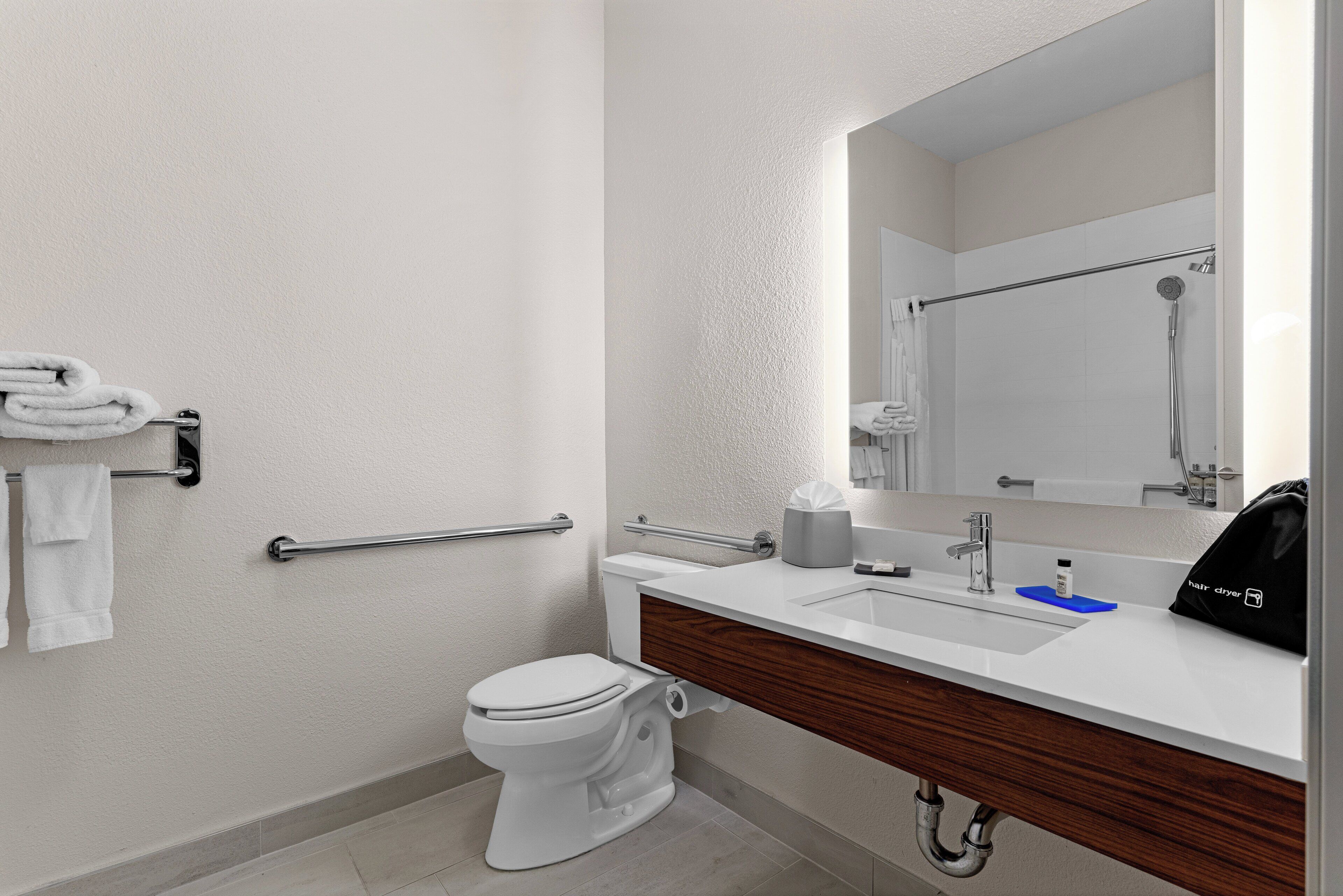 A modern bathroom with a toilet, sink, and shower.