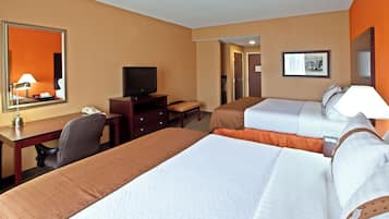 Una habitación de hotel con dos camas, un escritorio, un televisor y un espejo.
