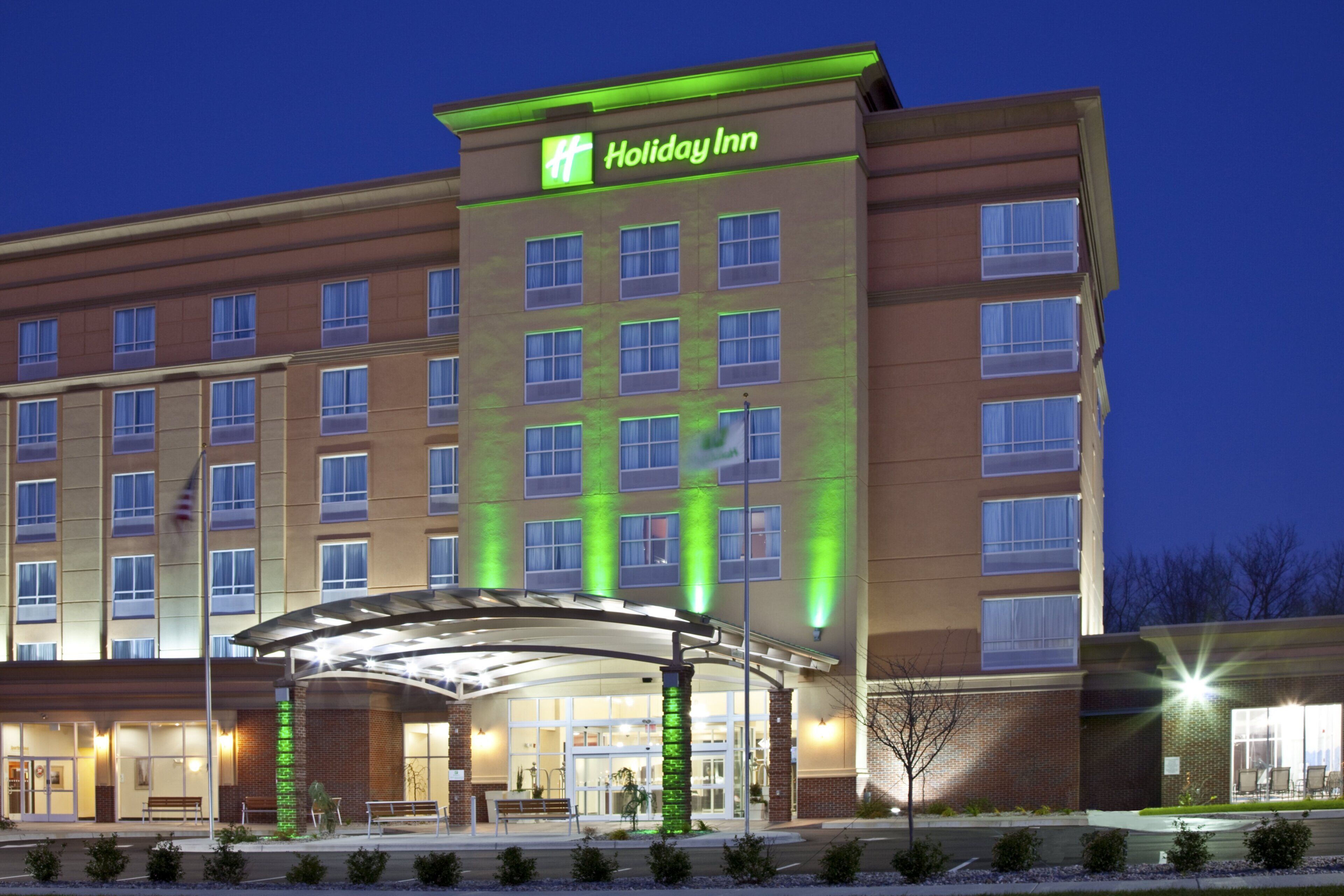 Ein Holiday Inn Hotel mit moderner Fassade, zahlreichen Fenstern und einem überdachten Eingangsbereich.