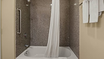 A bathroom with a bathtub, a shower, and a towel rack.